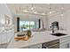 Modern kitchen with white cabinets, island, and view into living area at 5190 Foothills Preserve Loop, Mount Dora, FL 32757