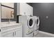 Modern laundry room with white cabinets and matching washer and dryer at 5190 Foothills Preserve Loop, Mount Dora, FL 32757