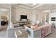 Open living room with brick accent wall, plush seating, and views into adjacent bedroom and kitchen at 5190 Foothills Preserve Loop, Mount Dora, FL 32757