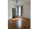 Bright bedroom with wood-look floors and gray curtains at 5500 Metrowest Blvd # 101, Orlando, FL 32811