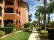 Exterior of condo building with walkway, landscaping, and palm trees at 5500 Metrowest Blvd # 101, Orlando, FL 32811