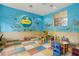 Colorful ' playroom with tables, chairs, and ocean mural at 5500 Metrowest Blvd # 101, Orlando, FL 32811