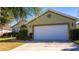 Green house with white garage door, landscaping, and a paved driveway at 5649 Magnolia Bloom Ter, Oviedo, FL 32765