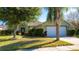 Green house exterior with a two-car garage and manicured lawn at 5649 Magnolia Bloom Ter, Oviedo, FL 32765