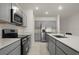 Modern kitchen with gray cabinets, stainless steel appliances, and quartz countertops at 640 Reggie Rd, Winter Haven, FL 33884