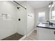 Bright bathroom showcasing a tiled shower with black fixtures, and a white vanity with black countertop at 718 N Grandview Ave, Daytona Beach, FL 32118