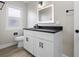 Bathroom featuring a white vanity with a black countertop, modern lighted mirror and wood-look flooring at 718 N Grandview Ave, Daytona Beach, FL 32118
