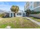 Cozy home exterior with a well-maintained lawn, mature palm trees, and a stone pathway to the entryway at 718 N Grandview Ave, Daytona Beach, FL 32118