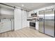 Well-appointed kitchen features wood floors, stainless appliances, and a sliding barn door at 718 N Grandview Ave, Daytona Beach, FL 32118