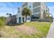 Exterior shot featuring a yard with a mature palm tree, stone walkway, and building architecture at 718 N Grandview Ave, Daytona Beach, FL 32118