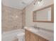 Updated bathroom with tiled shower, modern fixtures, and vanity with stone countertop at 7760 Windbreak Rd, Orlando, FL 32819