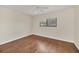 Bright bedroom featuring hardwood floors, ceiling fan and a large window overlooking neighborhood at 7760 Windbreak Rd, Orlando, FL 32819