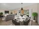 An open-concept dining room with a modern table set, chandelier, and seamless flow to the living area at 7760 Windbreak Rd, Orlando, FL 32819