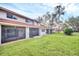 Rear exterior of the townhome with a screened lanai and expansive lawn at 7760 Windbreak Rd, Orlando, FL 32819