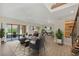 Bright living room featuring wood floors, a ceiling fan, and sliding glass doors to a screened patio at 7760 Windbreak Rd, Orlando, FL 32819