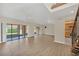 Large living room with wood-look tile flooring and sliding glass doors to patio at 7760 Windbreak Rd, Orlando, FL 32819