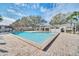 Community pool featuring a brick paver deck, lounge chairs, and a clubhouse with a landscaped surround at 7760 Windbreak Rd, Orlando, FL 32819