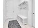 White entryway with bench, shoe storage, and hooks at 8298 Lookout Pointe Dr, Windermere, FL 34786