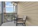 Small screened balcony with two chairs and a small table at 9051 Treasure Trove Ln # 301, Kissimmee, FL 34747