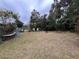 A spacious backyard with lush grass, mature trees, and a hammock, perfect for relaxation and outdoor activities at 127 W Palmetto Ave, Deland, FL 32720