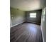 This empty, window-lit room boasts dark wood floors, awaiting personal touches to create a welcoming atmosphere at 127 W Palmetto Ave, Deland, FL 32720