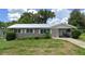 Ranch-style home with carport and mature landscaping at 127 W Palmetto Ave, Deland, FL 32720