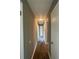 A hallway featuring wood floors and neutral walls leads to various rooms, enhanced by a ceiling light at 127 W Palmetto Ave, Deland, FL 32720