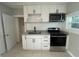 Renovated kitchen with white cabinets and granite countertops at 127 W Palmetto Ave, Deland, FL 32720