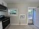 Kitchen area with microwave, electric oven, window, and an AC unit installed through the wall at 127 W Palmetto Ave, Deland, FL 32720