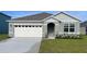 One-story house with gray siding, white garage door, and landscaped lawn at 1320 Hanoverian Dr, Lake Alfred, FL 33850