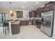 Modern kitchen with dark wood cabinets, stainless steel appliances, and granite countertops at 1427 Wexford Way, Davenport, FL 33896