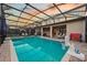Private screened-in pool area with a hot tub, mounted TV, and basketball hoop for endless outdoor fun and relaxation at 1427 Wexford Way, Davenport, FL 33896