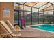 Relaxing poolside lounge chairs under a screened enclosure, perfect for enjoying the pool and outdoor amenities at 1427 Wexford Way, Davenport, FL 33896