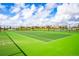 Green tennis court with chain-link fence and residential backdrop at 1427 Wexford Way, Davenport, FL 33896