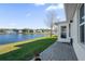 Backyard patio with a scenic view of the lake, fountain, and well-maintained lawn at 164 Pergola Pl, Ormond Beach, FL 32174