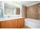 Bathroom with double sinks, wood cabinets, tub and shower combination, and neutral tones at 164 Pergola Pl, Ormond Beach, FL 32174