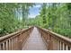Community boardwalk with wooden railings that is surrounded by trees and foliage at 164 Pergola Pl, Ormond Beach, FL 32174