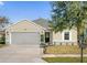 Inviting single-story home with lush front lawn, two-car garage, and decorative garden bed at entry at 164 Pergola Pl, Ormond Beach, FL 32174