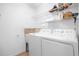A laundry room with washer, dryer, shelving, laundry sink and neutral wall paint at 164 Pergola Pl, Ormond Beach, FL 32174