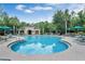 Enjoy the community's sparkling swimming pool with lounge chairs and umbrella-covered tables at 164 Pergola Pl, Ormond Beach, FL 32174