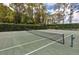 Outdoor tennis court surrounded by tall trees at 164 Pergola Pl, Ormond Beach, FL 32174