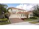 Two-story house with tile roof, large driveway, and landscaping at 16767 Rusty Anchor Rd, Winter Garden, FL 34787