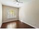 A cozy bedroom featuring a window that provides natural light and hardwood floors at 1712 Whitney Isles Dr, Windermere, FL 34786