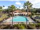 A community pool surrounded by palm trees, lounge chairs, and lush landscaping for a tropical resort-like experience at 1712 Whitney Isles Dr, Windermere, FL 34786