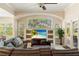 Bright living room featuring large windows, a built-in entertainment center, and access to an outdoor patio at 1712 Whitney Isles Dr, Windermere, FL 34786