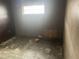 Empty bedroom with worn flooring and damaged walls, ready for renovation at 1804 Mable Butler Ave, Orlando, FL 32805