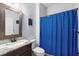 Bathroom featuring a vanity with stone countertops, a toilet, and a blue curtain at 30810 Nocatee Trl, Sorrento, FL 32776