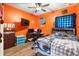 Bedroom featuring orange painted walls, a bed, and a ceiling fan at 30810 Nocatee Trl, Sorrento, FL 32776