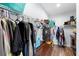 Walk-in closet featuring wire shelving, wood look floors, hanging clothes and storage chest at 30810 Nocatee Trl, Sorrento, FL 32776