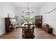 Bright dining room features wood floors, a chandelier, a piano, and a large window for natural light at 30810 Nocatee Trl, Sorrento, FL 32776